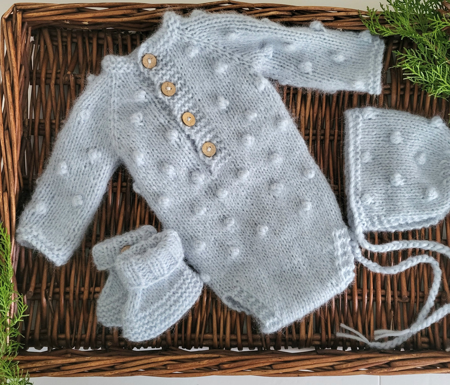 pale blue handknit baby romper with long sleeves, knit baby bonnet and bootie set for newborn photography or as a baby shower gift for a little boy