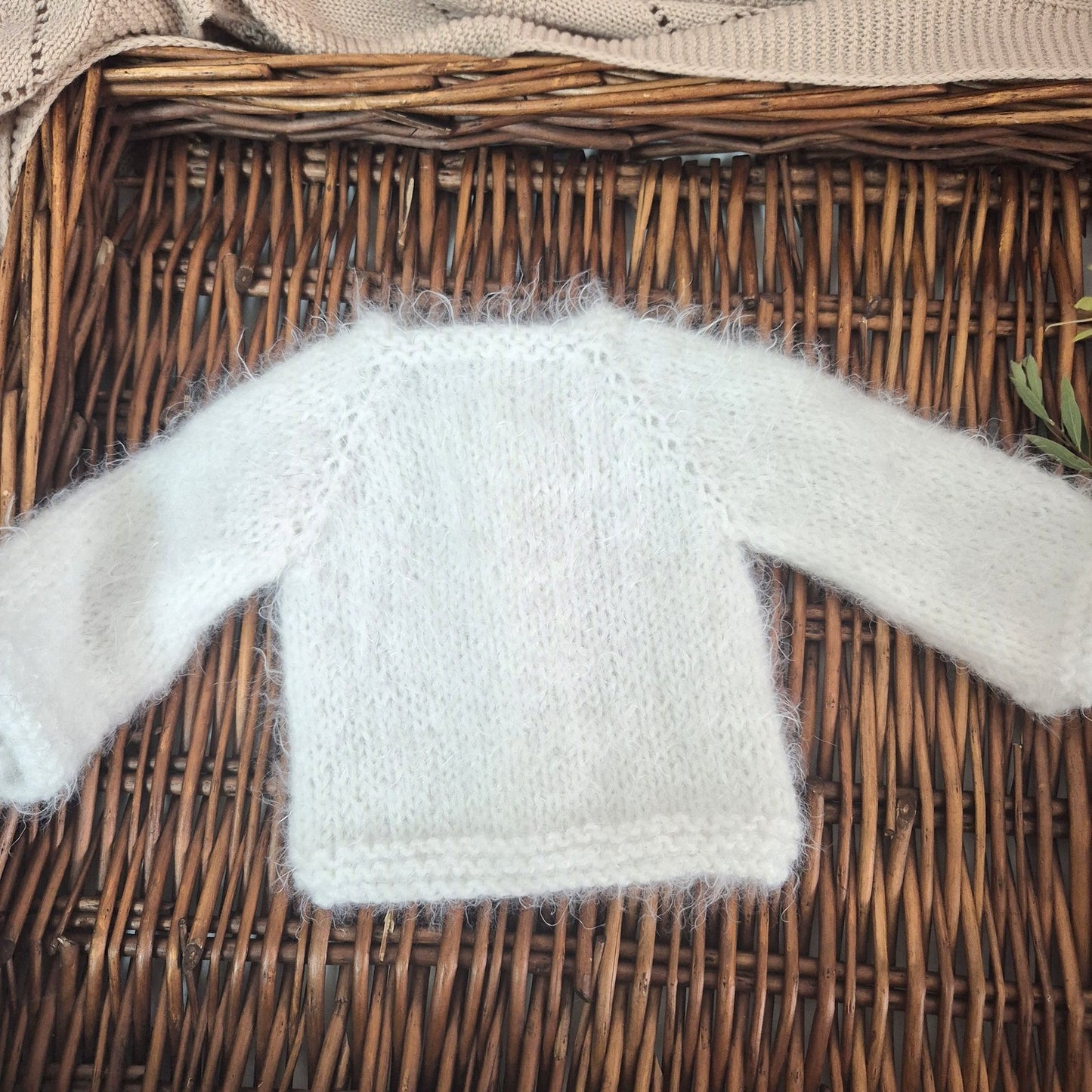 White knitted sweater on a wicker surface