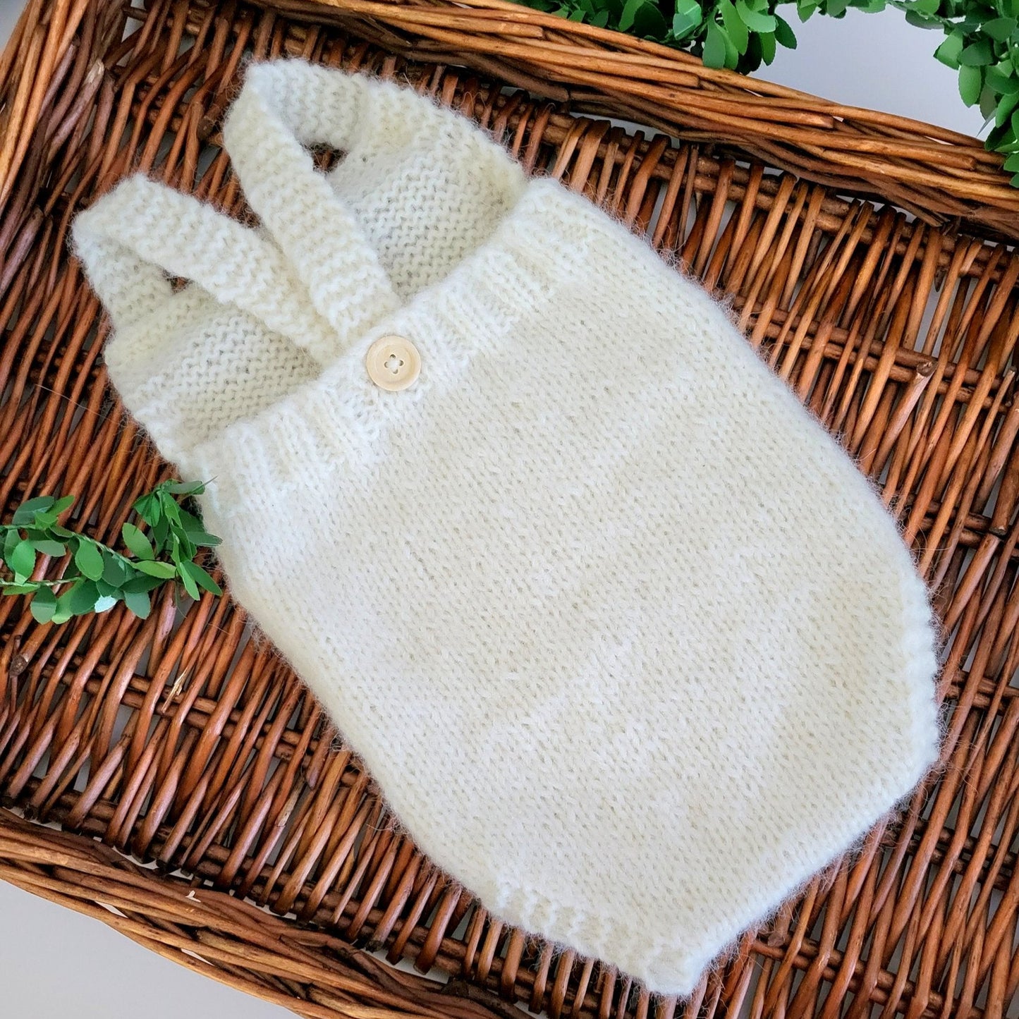 handknit baby romper in a simple classic style, with shoulder straps