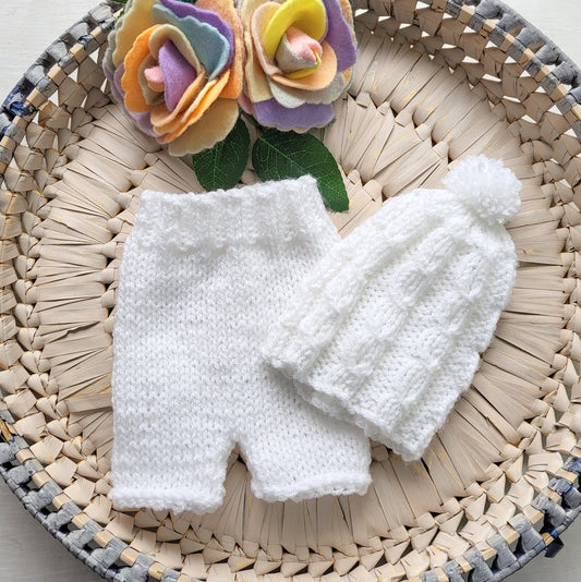 white knitted newborn baby shorts and cabled pom pom hat set