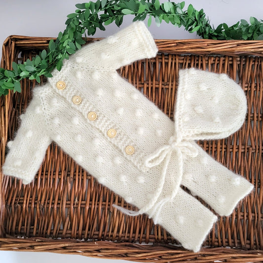 cream hand knit baby pajama suit with matching bonnet and a popcorn bubble pattern