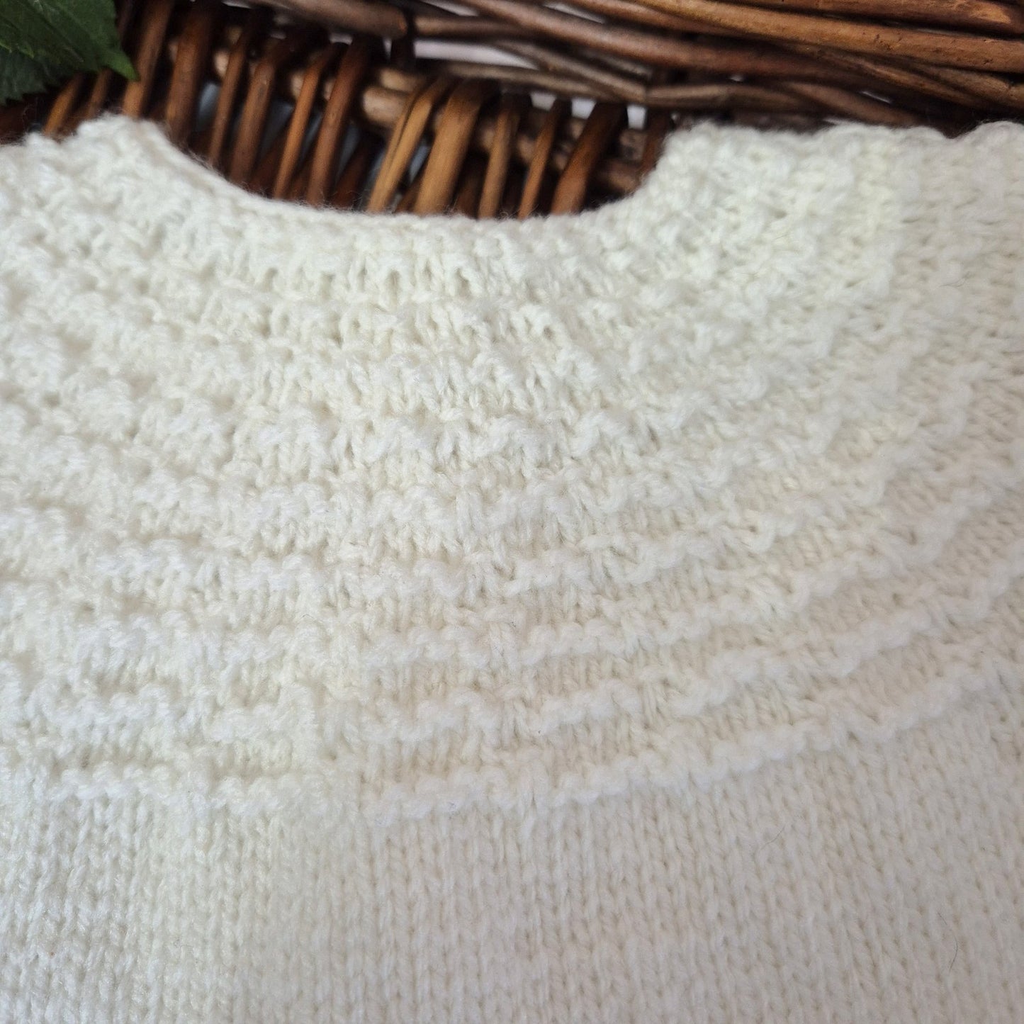 Close-up of textured white fabric with a wicker basket in the background