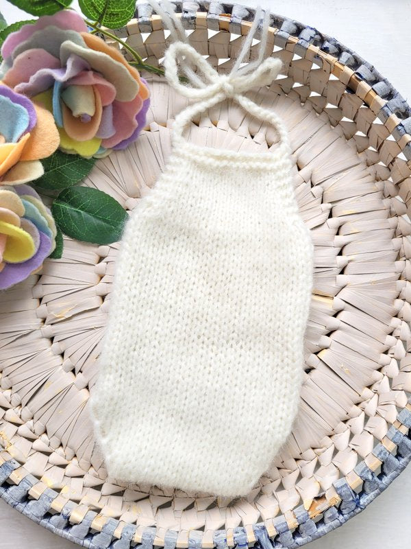 handknit cream newborn romper for a photo shoot