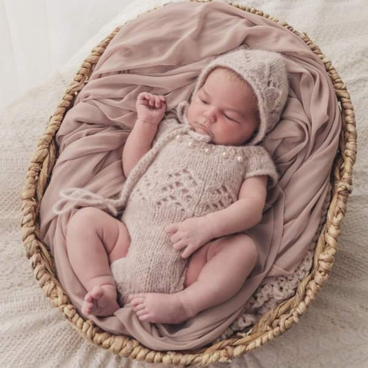 pale pink newborn romper with lace front, pearls and a matching bonnet