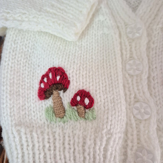 White knitted fabric with embroidered red mushrooms