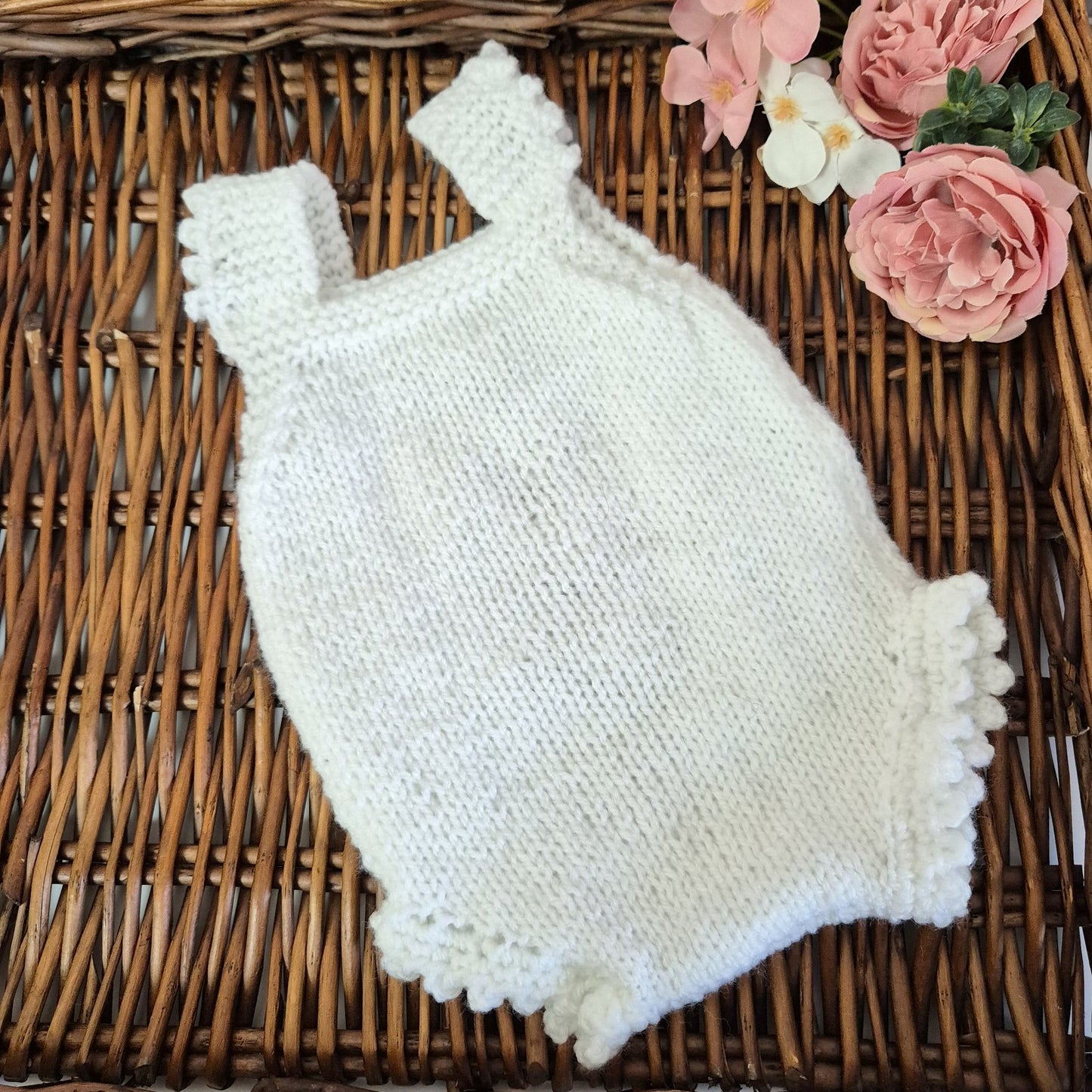 A sweet handknit lace and popcorn romper for a baby girl from newborn to 3 months old.
The darling little romper has a lace and popcorn pattern panel down the front, with scalloped frill on the legs and shoulder straps.