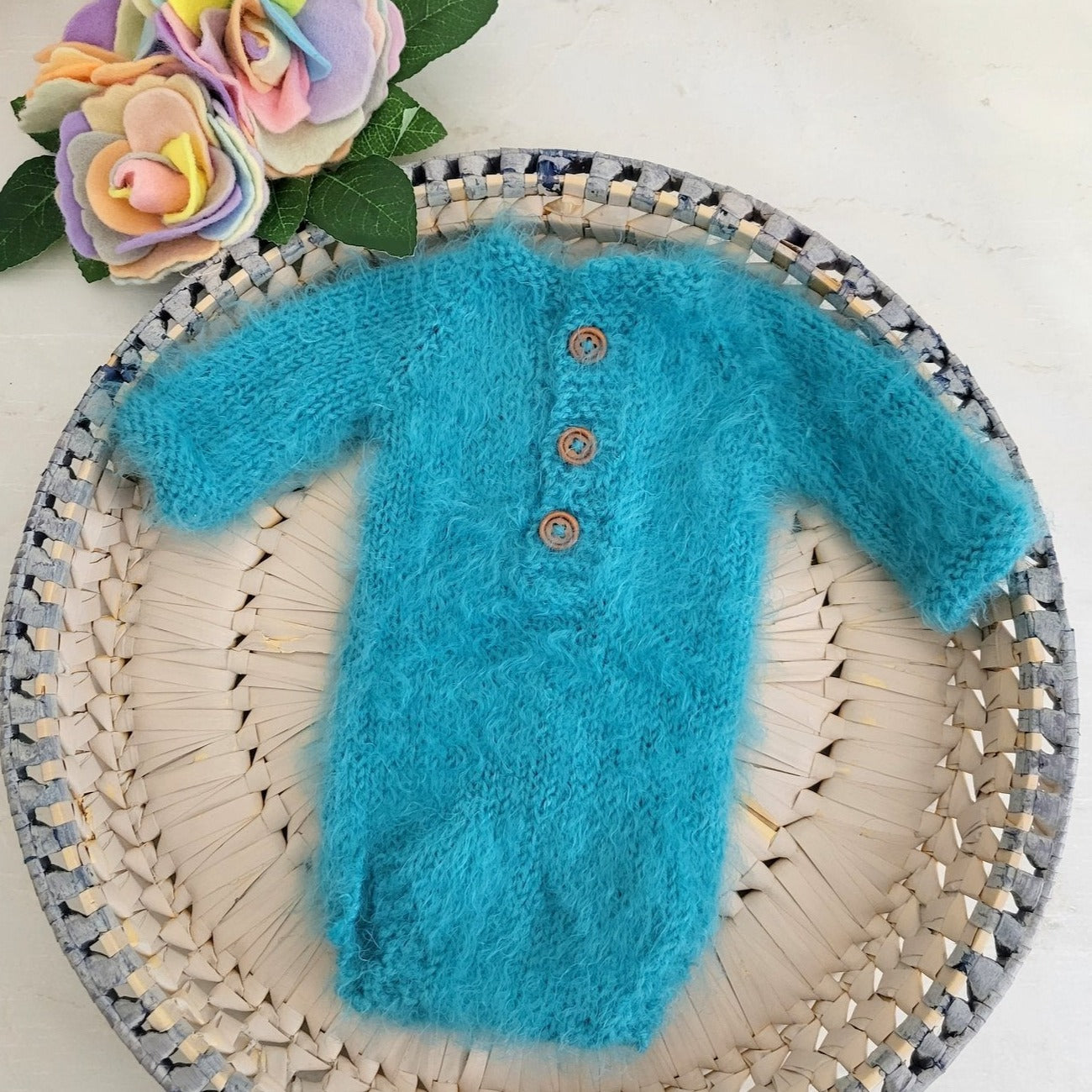 fluffy blue knitted long sleeved onesie romper for a newborn baby photo shoot