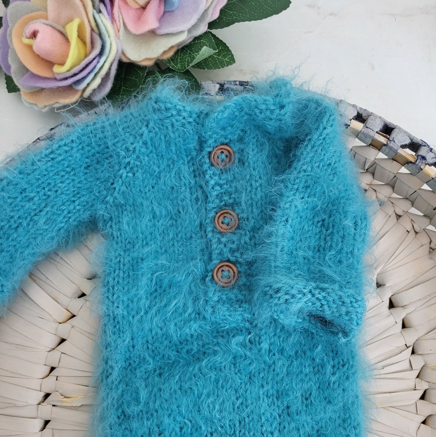 closeup of wooden buttons on a fluffy long sleeved onesie romper for photo prop use