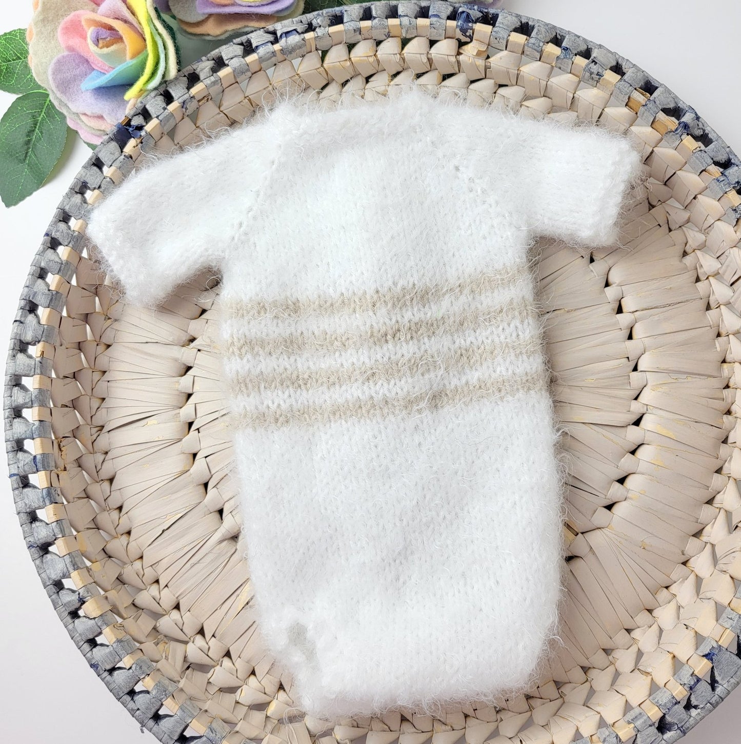 back view of the handknit white and beige newborn romper