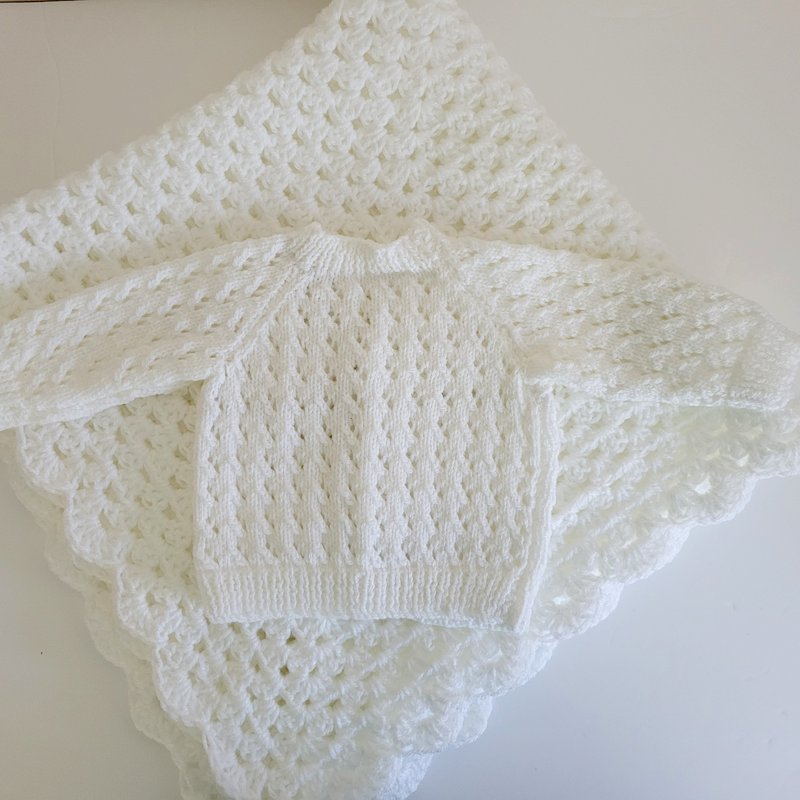 back view of white knit baby jumper and blanket gift set