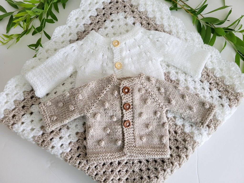 white and beige newborn gift set blanket and two jumpers