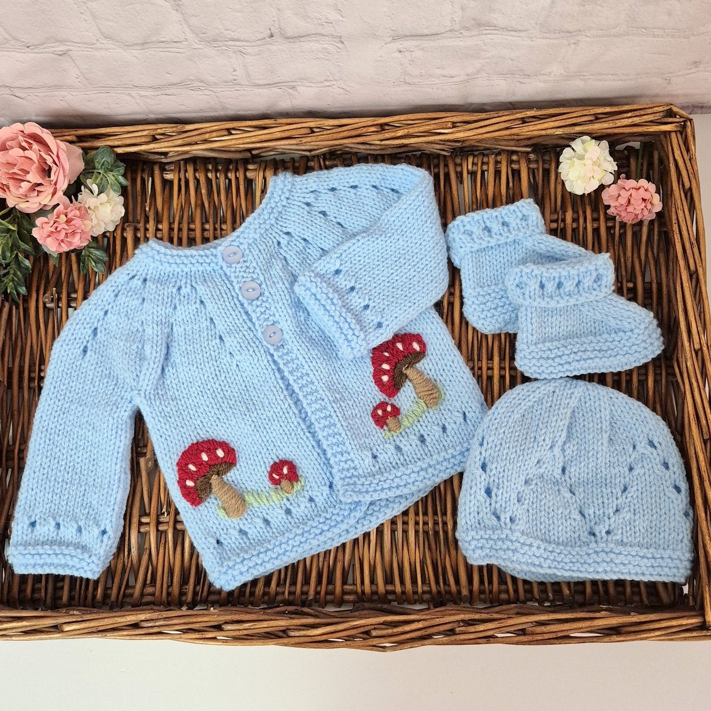 Handmade Knitted gift set for a baby boy. The set comprises a gorgeous hand knit baby cardigan, booties and hat set in baby blue yarn, with red toadstools - mushrooms embroidered on both sides at the front.
Designed to fit a 0-3 month old baby. 