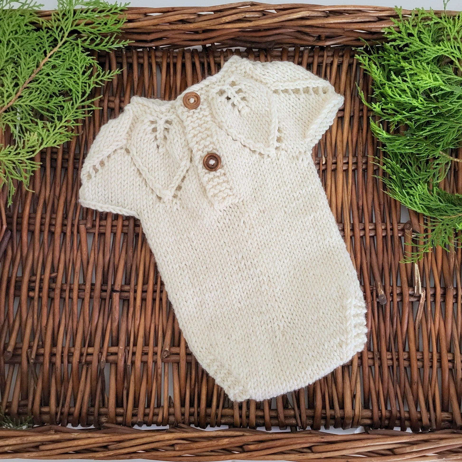 cream knitted newborn romper with a leaf pattern on the neckline, sleeveless romper for use as a photography prop