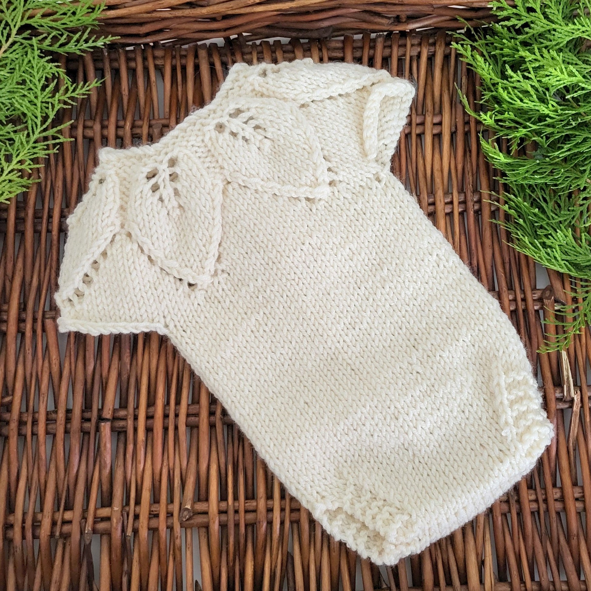 knitted baby romper with a leaf pattern
