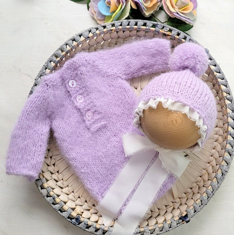 lavender purple long sleeved romper and pom pom bonnet with long white ribbon ties, for a newborn baby girl photo shoot