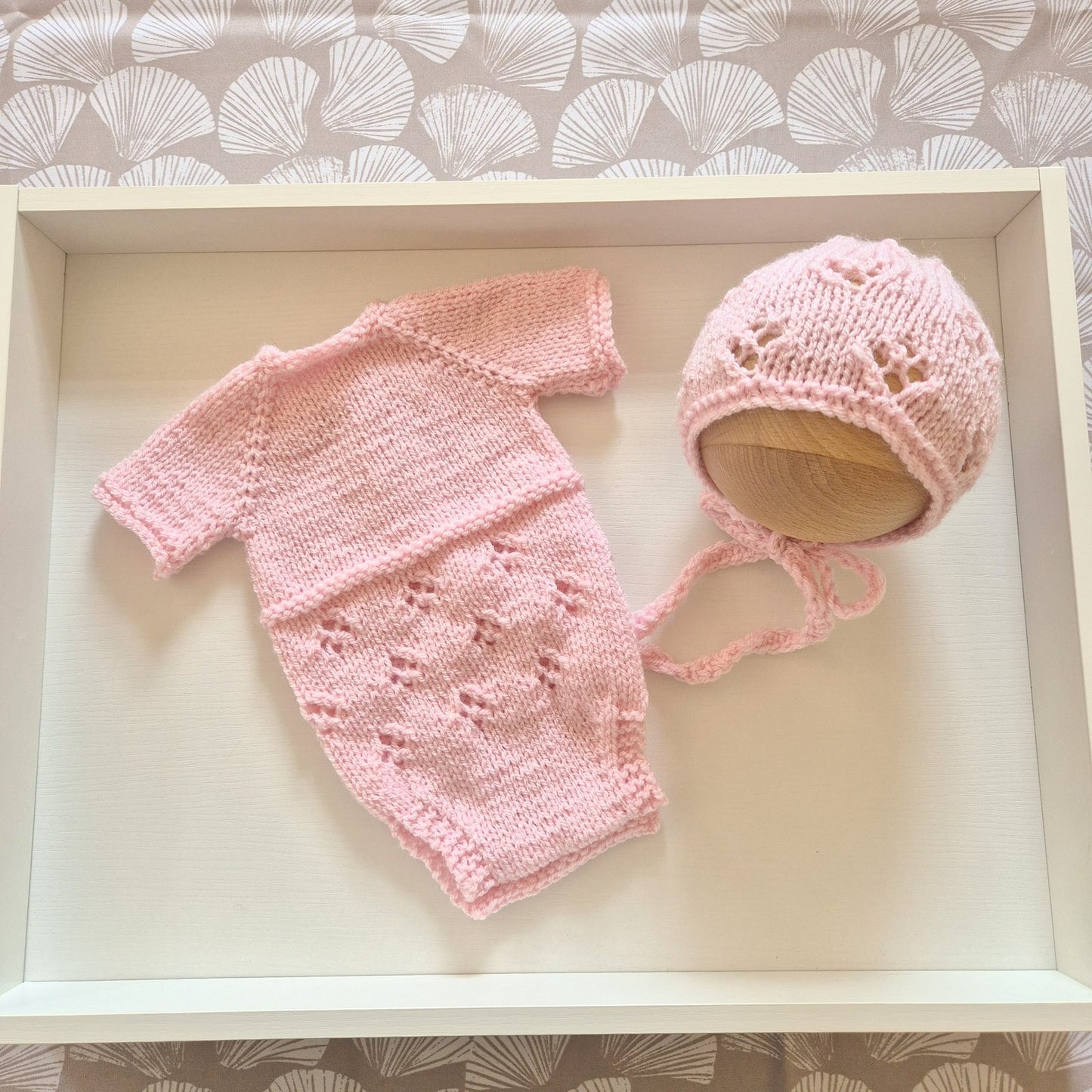 Pink Handknit Newborn Baby Romper and Bonnet Set. Knit in soft quality acrylic yarn, in an eyelet lace pattern. This short sleeved bodysuit style romper is suitable as a hospital coming home outfit, newborn photo prop or baby shower gift. Ready to send.
The little romper has buttons at the neck that can be worn to the back or the front,&nbsp; and for buttons for quick diaper changes.
Shipped from the UK, in an organza bag that is ready for you to gift.