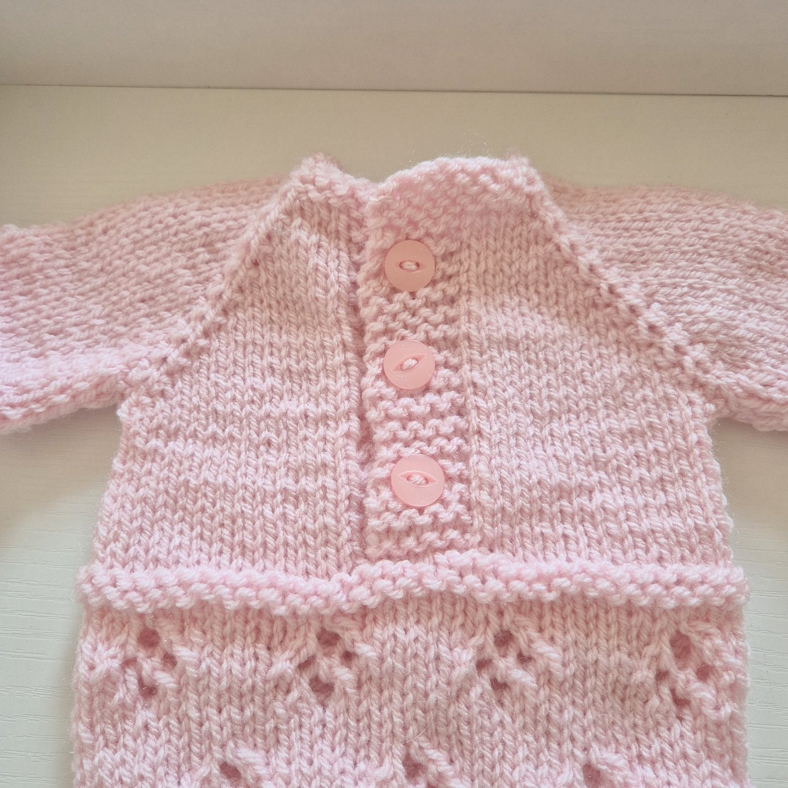 Pink Handknit Newborn Baby Romper and Bonnet Set. Knit in soft quality acrylic yarn, in an eyelet lace pattern. This short sleeved bodysuit style romper is suitable as a hospital coming home outfit, newborn photo prop or baby shower gift. Ready to send.
The little romper has buttons at the neck that can be worn to the back or the front,&nbsp; and for buttons for quick diaper changes.
Shipped from the UK, in an organza bag that is ready for you to gift.