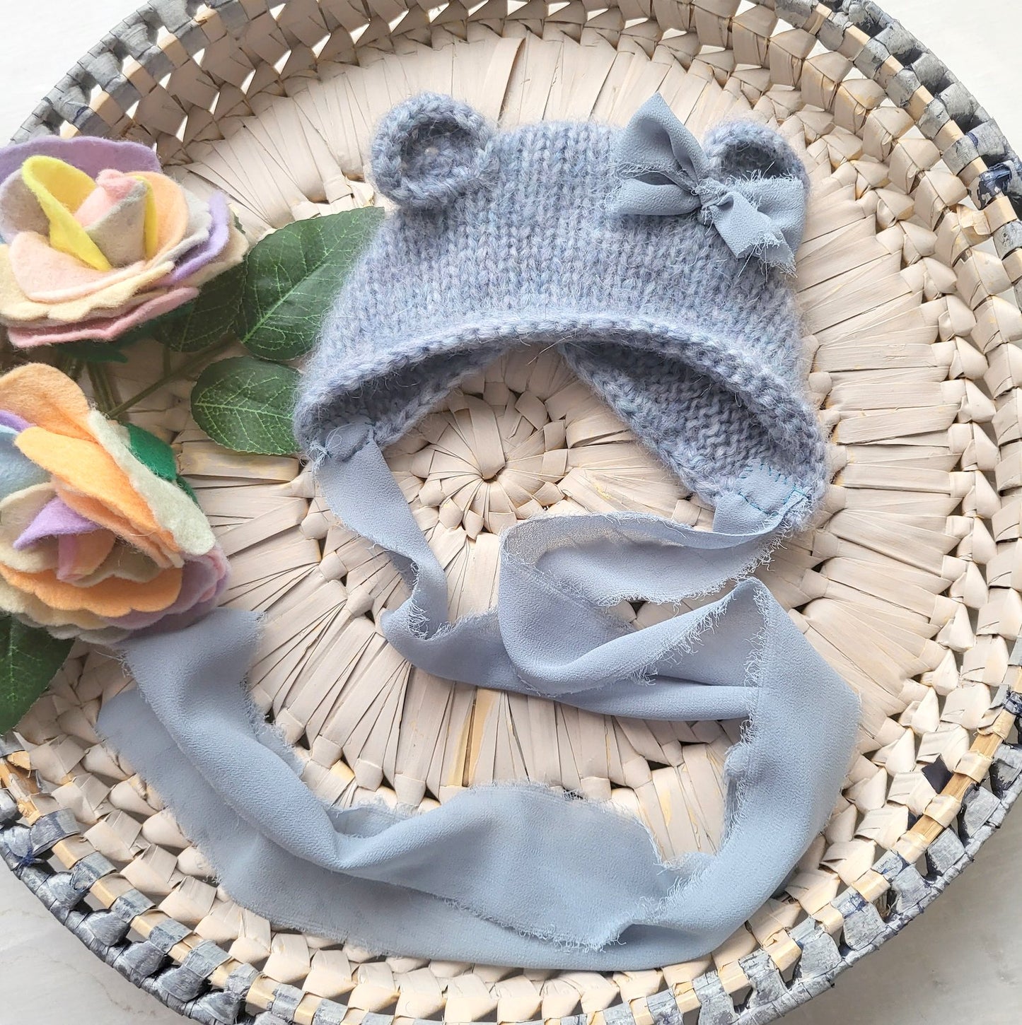 blue knitted baby bear bonnet with bow and frayed ribbons