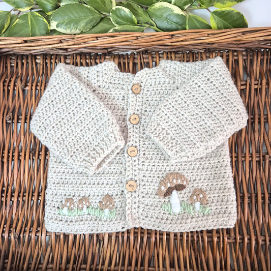 A gorgeous handmade crochet baby cardigan to fit a baby of 0-6 months This little jumper has coconut shell buttons and little toadstools embroidered on the front. 