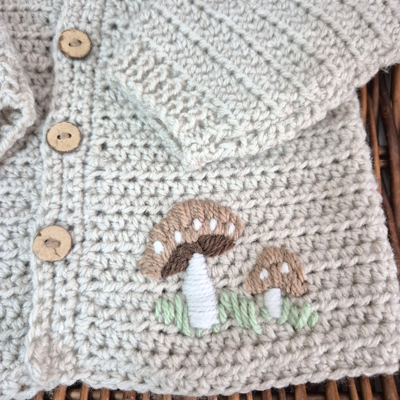 A gorgeous handmade crochet baby cardigan to fit a baby of 0-6 months This little jumper has coconut shell buttons and little toadstools embroidered on the front. 