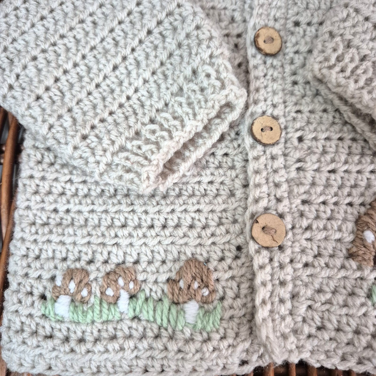 A gorgeous handmade crochet baby cardigan to fit a baby of 0-6 months This little jumper has coconut shell buttons and little toadstools embroidered on the front. 