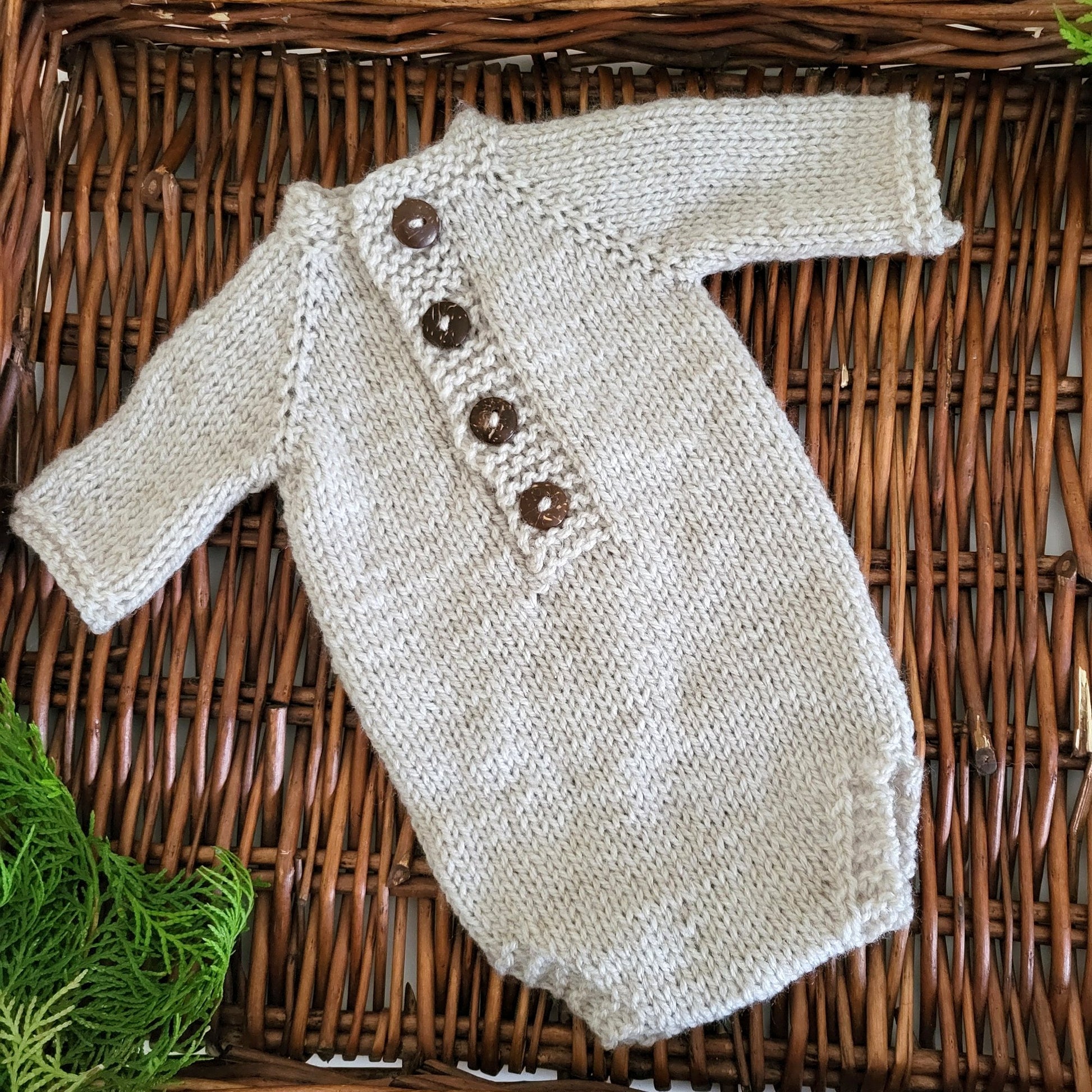 knitted newborn romper in light beige with wooden buttons
