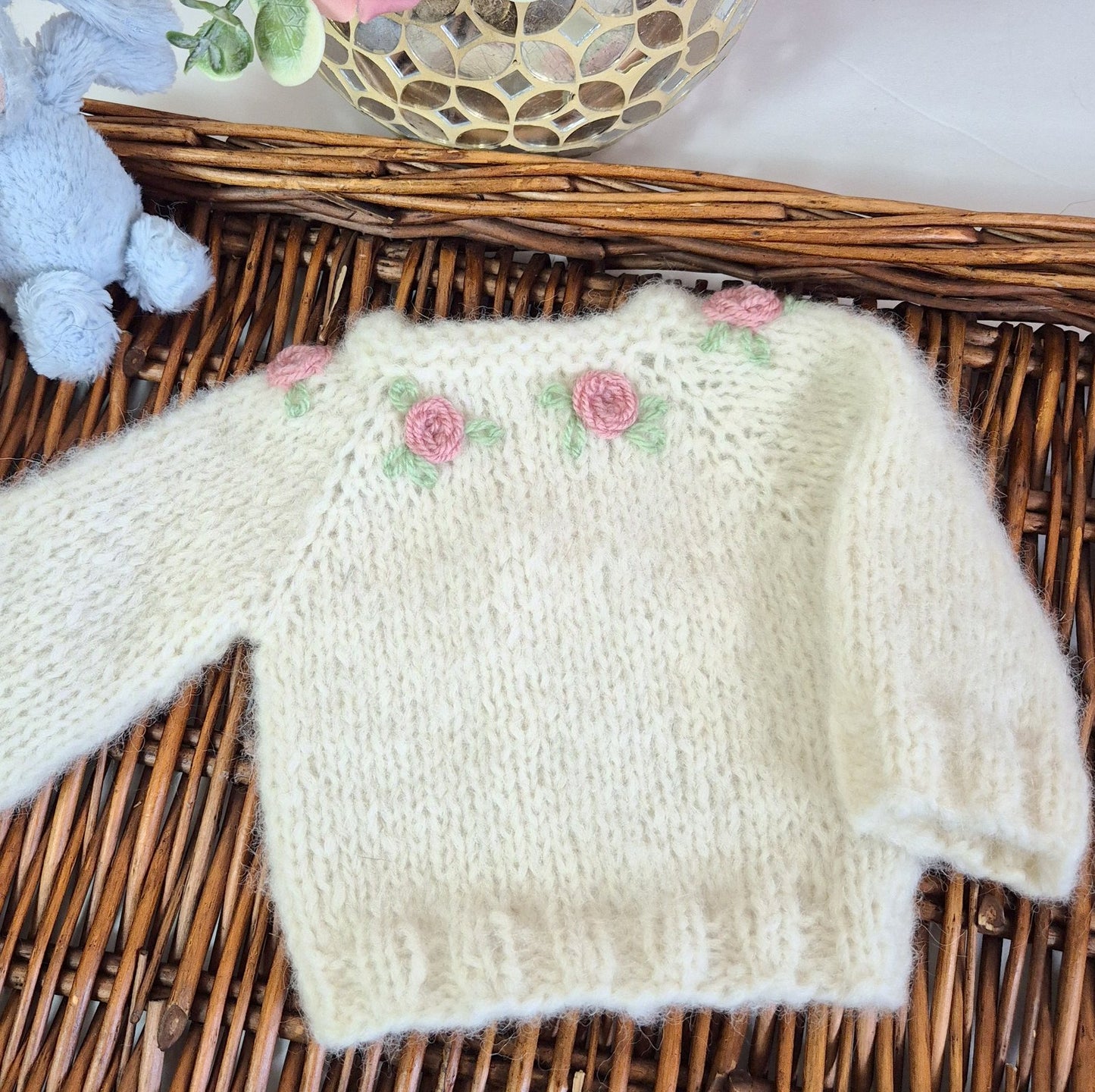 Cream Knitted Baby Girl Coming Home Outfit with pink embroidered roses. Newborn Photo Prop.
This adorable set includes a hand made sweater, pants and bonnet. All knit in soft cream alpaca yarn, with flowers embroidered around the neckline.