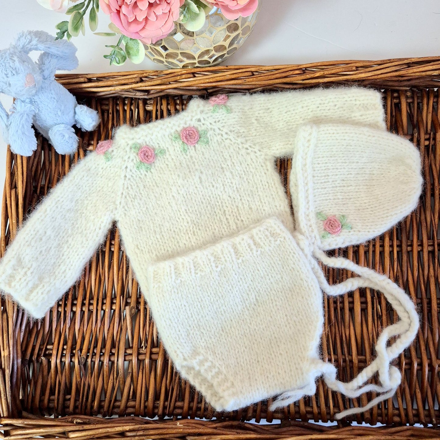 Cream Knitted Baby Girl Coming Home Outfit with pink embroidered roses. Newborn Photo Prop.
This adorable set includes a hand made sweater, pants and bonnet. All knit in soft cream alpaca yarn, with flowers embroidered around the neckline.