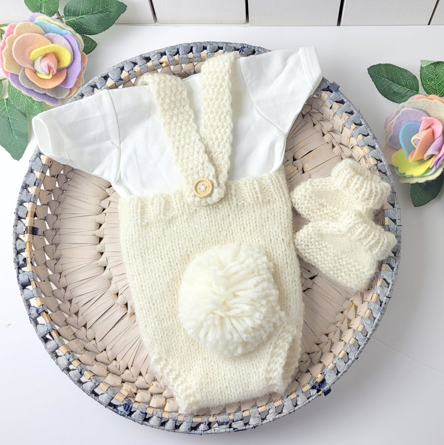 pom pom tail on the cream knitted baby romper with matching booties