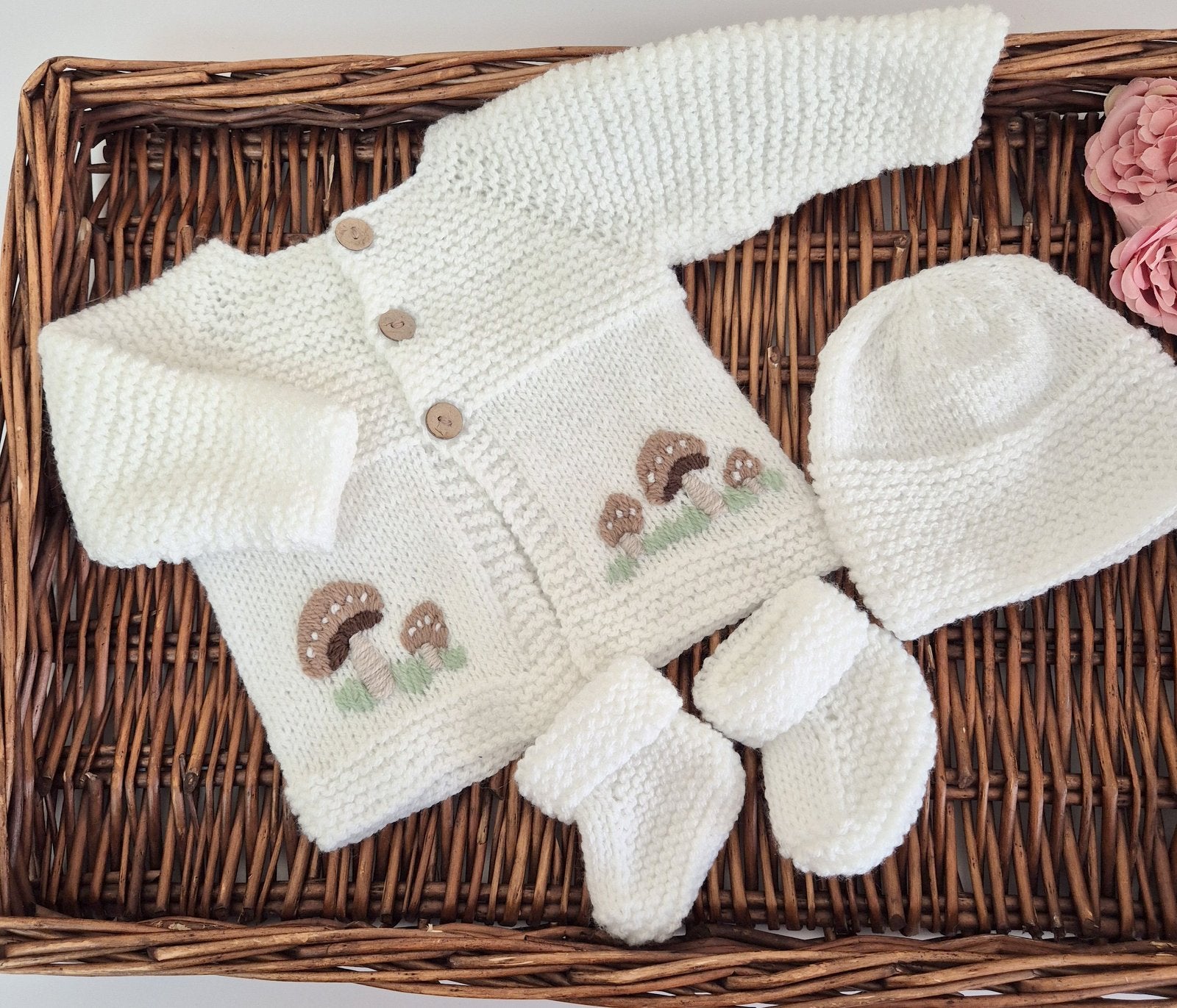 White hand knit baby cardigan, hat and booties set. Embroidered with little brown button mushrooms. Jumper, 0-6 months Sweater.

This cardigan has a raised pattern on the chest, with coconut shell buttons, and toadstool embroidery on the front. A matching white hat and booties complete the set.

Knit in soft acrylic yarn, easy for a busy mum to wash.