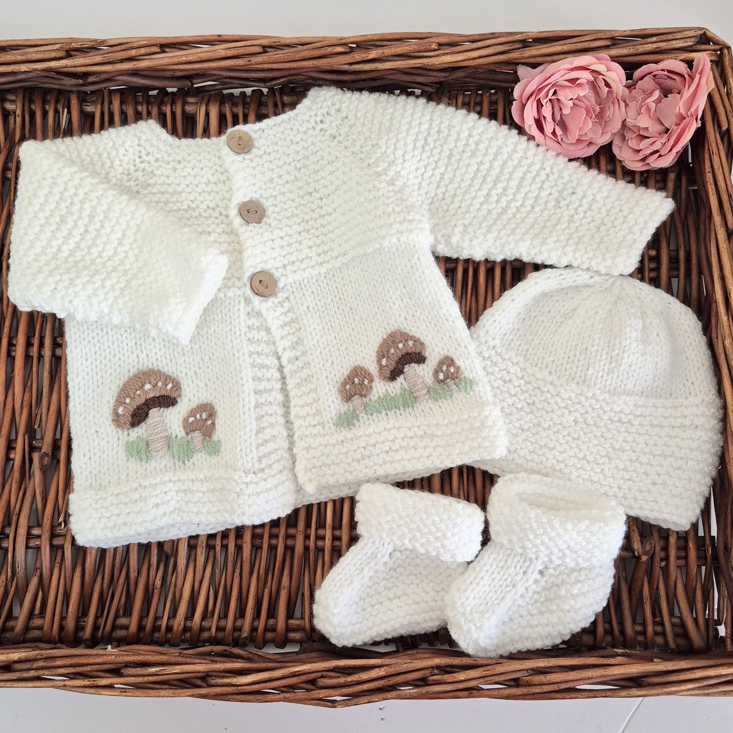 White hand knit baby cardigan, hat and booties set. Embroidered with little brown button mushrooms. Jumper, 0-6 months Sweater.

This cardigan has a raised pattern on the chest, with coconut shell buttons, and toadstool embroidery on the front. A matching white hat and booties complete the set.

Knit in soft acrylic yarn, easy for a busy mum to wash.
