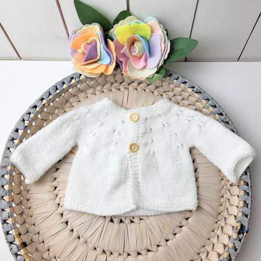 white knitted newborn baby jumper with two wooden buttons on the front. ready to send