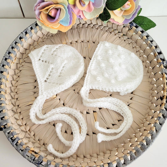 white knitted baby bonnets with lace or bobble pattern