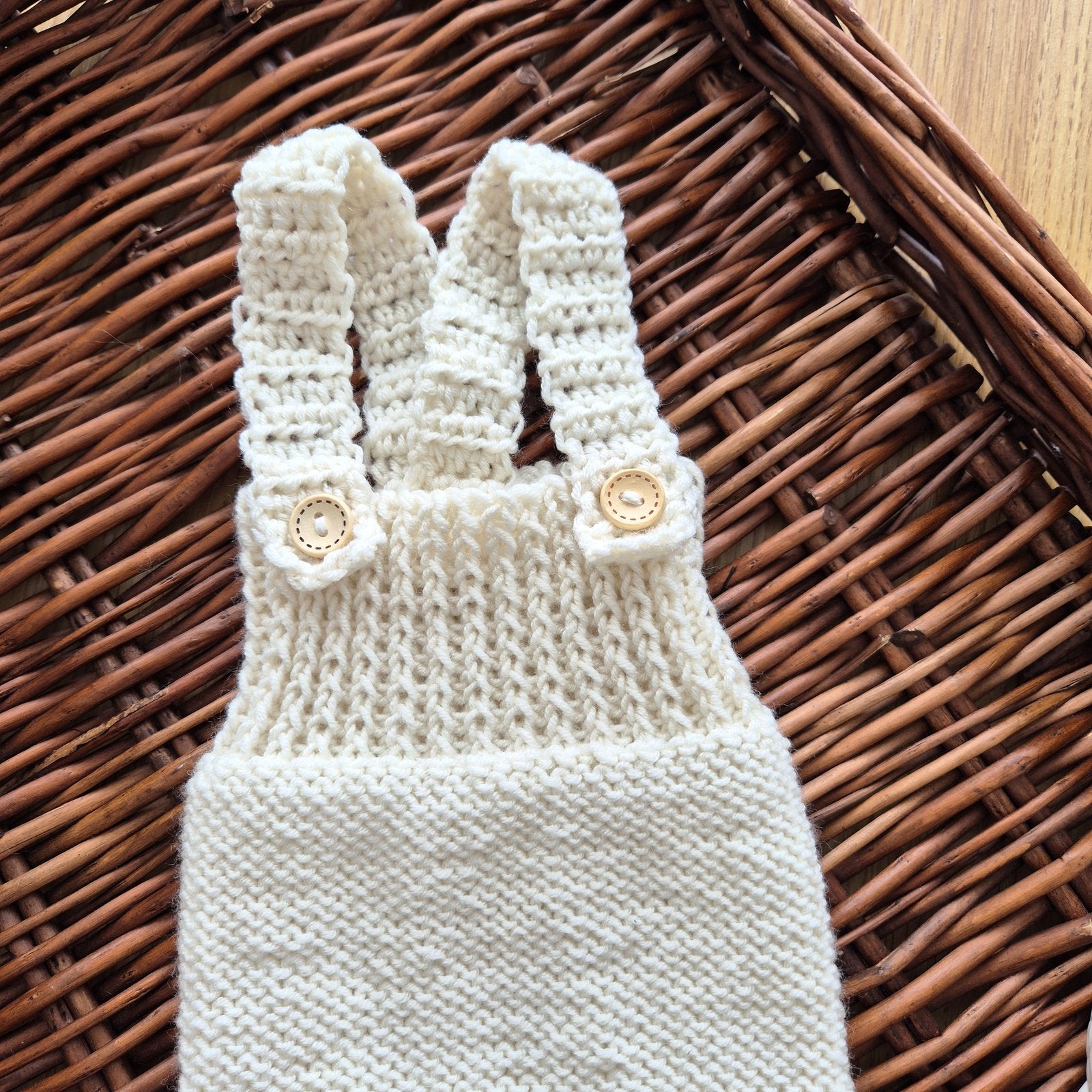 Ready to send knitted baby romper with shoulder straps, suitable for newborn photography.
Knit in cream merino yarn, this little dungaree type romper has a wide ribbed chest, and garter stitching on the tummy/ diaper.