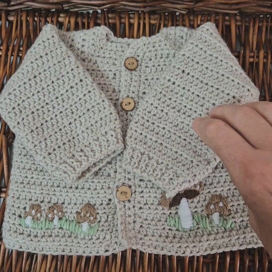 A gorgeous handmade crochet baby cardigan to fit a baby of 0-6 months This little jumper has coconut shell buttons and little toadstools embroidered on the front. 