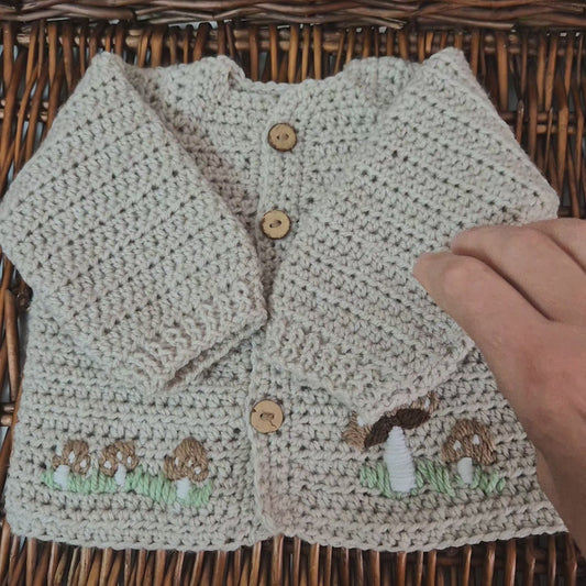 A gorgeous handmade crochet baby cardigan to fit a baby of 0-6 months This little jumper has coconut shell buttons and little toadstools embroidered on the front. 