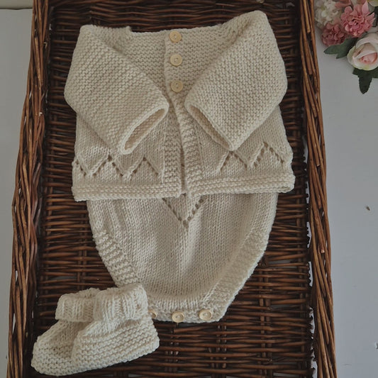 Handknit baby cardigan, romper and booties set. Ready to send. The outfit is made to fit a baby of 0-3 months old. Perfect as a baby shower gift or as a gorgeous set to match your baby's wardrobe.

The cardigan is knit with a chevron lace pattern on the edge, and a ridged pattern across the bodice and sleeves, with wooden buttons down the front. The matching romper has shoulder straps, the same chevron lace pattern, and buttons for diaper changes.