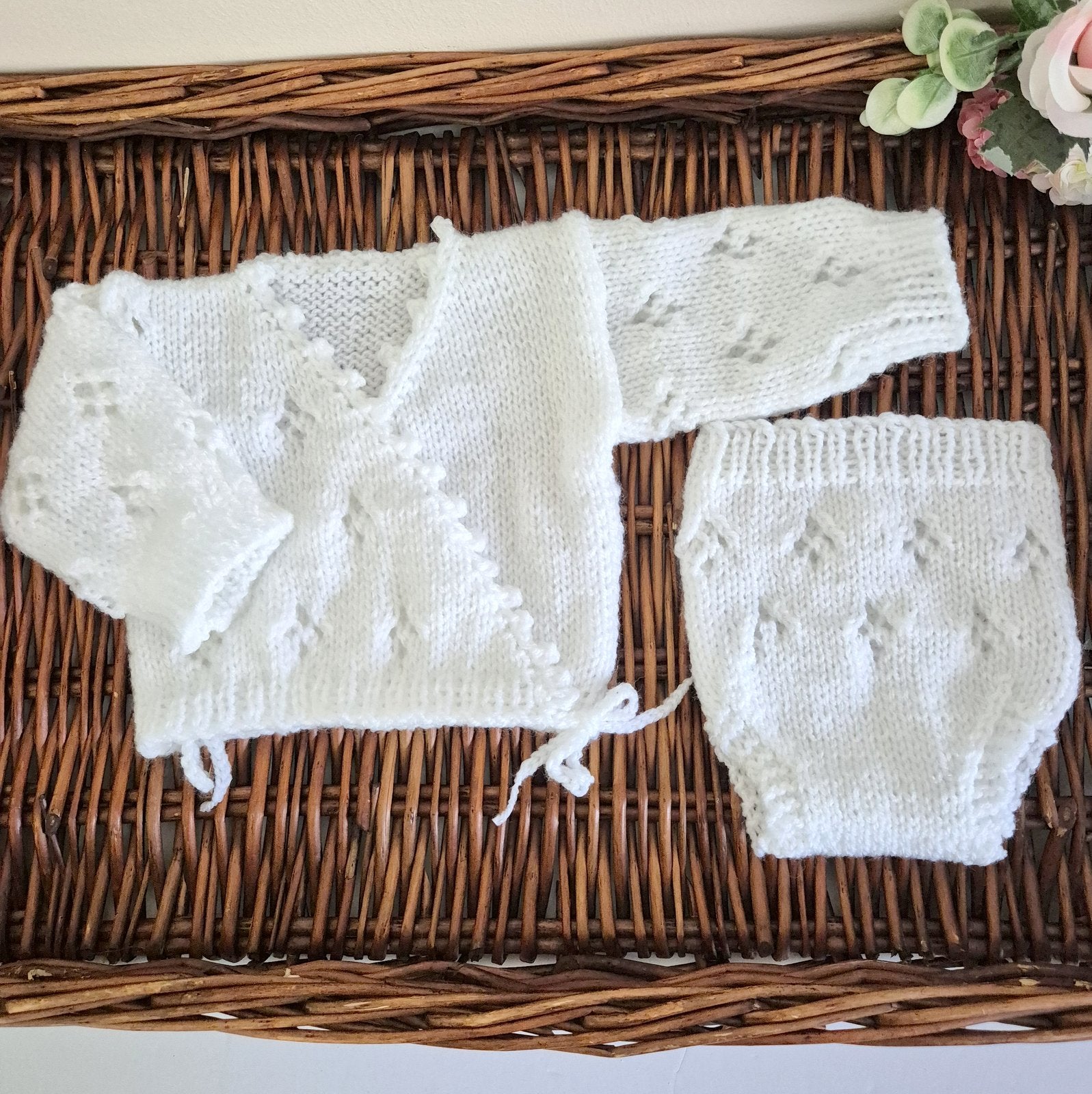 Hand knit baby girl cardigan outfit. Newborn cross over kimono style cardigan with a lace Pattern, scalloped edge, and long sleeves. The fronts have bow-ties at the edge.

Made in sizes Preemie / Newborn / 0-3 months
A pair of matching pants with the same pattern completes the outfit. Knit in soft acrylic yarn that is easy to wash.
This is perfect as a hospital coming home outfit, newborn photography prop or as a baby shower gift for a baby girl. All my knitwear is shipped in an organza bag, ready for you t