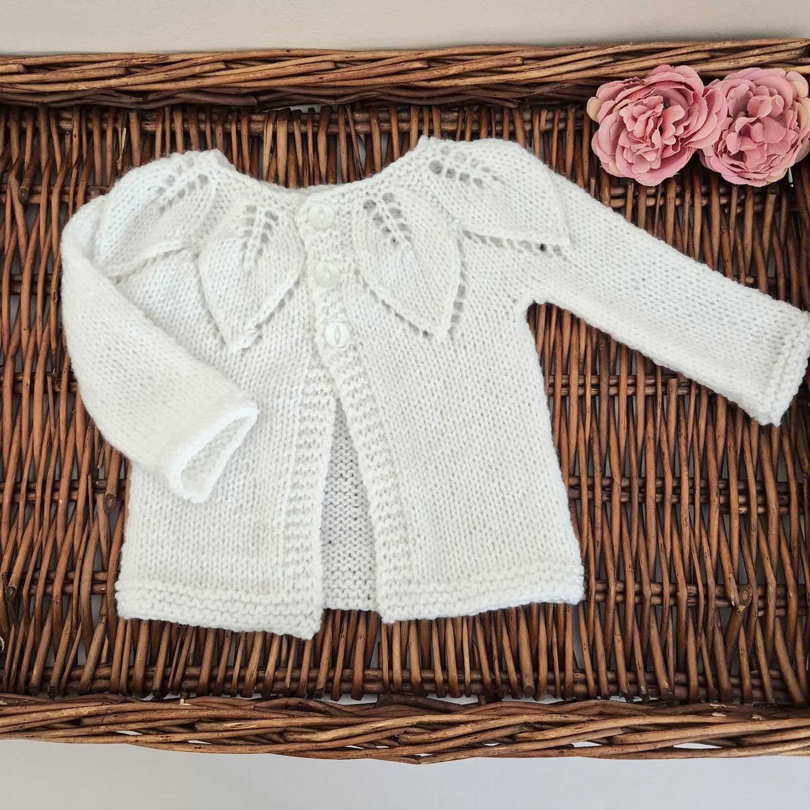 A gorgeous hand knit baby cardigan with a leaf pattern around the neckline, and little wooden buttons on the front. A simple, classic style that is suitable for baby boys or girls. 

Made to fit a baby either newborn or 1-6 months old. The newborn size is perfect as a pregnancy announcement, hospital coming home outfit, or newborn photography prop. The jumper is shipped in an organza bag, ready for you to give as a gift. 