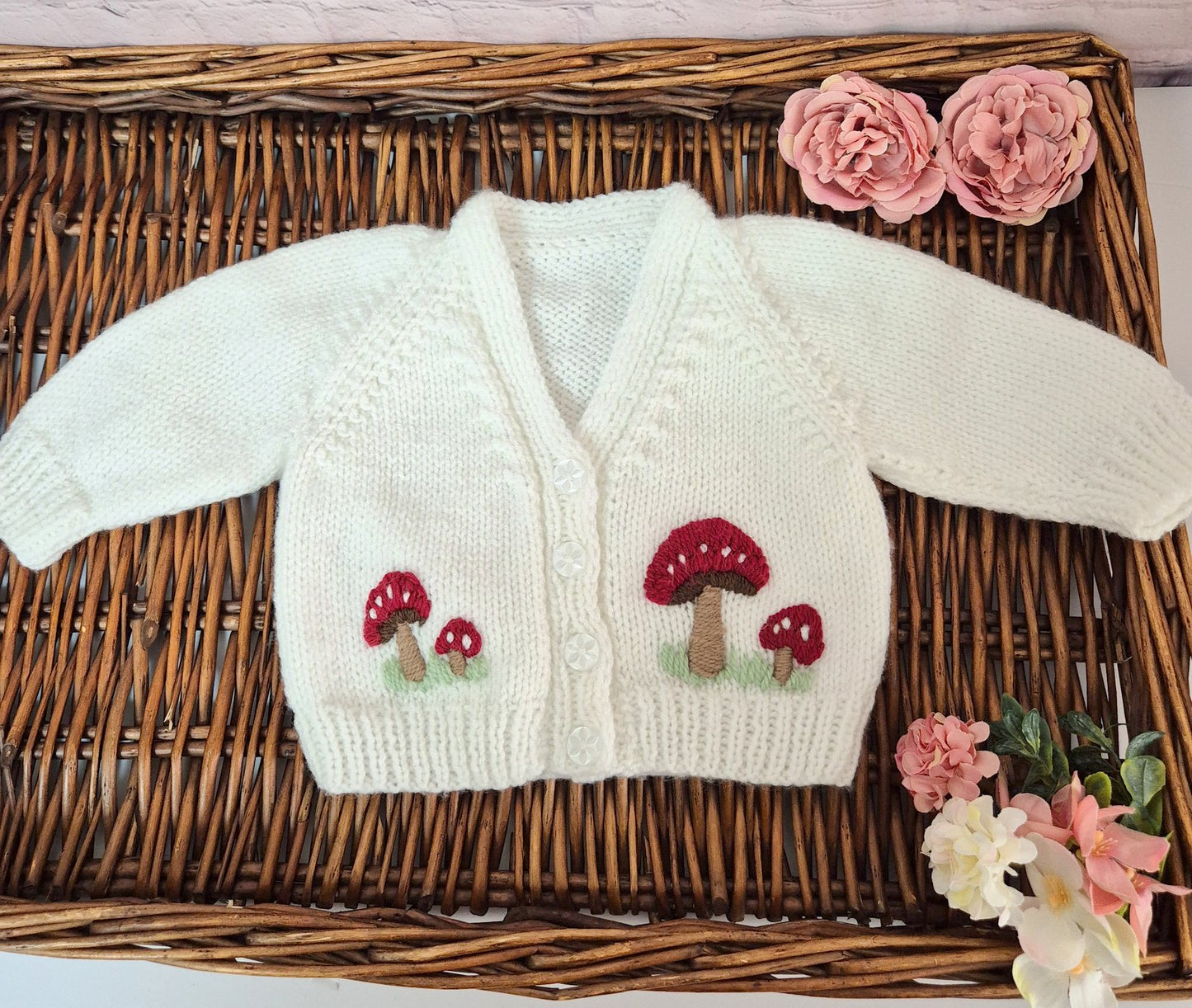 White hand knit baby cardigan with embroidered red toadstools. &nbsp;Jumper, 0-3 months Sweater
A gorgeous hand knit baby cardigan to fit a baby of 0-3 months&nbsp; This little jumper has white buttons on the top of the bodice, with&nbsp; little red toadstools embroidered on the front.&nbsp;