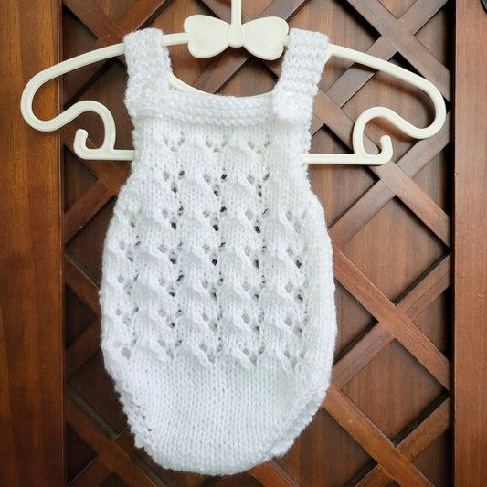 handknit baby girl romper in white with an all over lace pattern