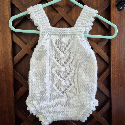 A sweet handknit lace and popcorn romper for a baby girl from newborn to 3 months old.

The darling little romper has a lace and popcorn pattern panel down the front, with scalloped frill on the legs and shoulder straps.