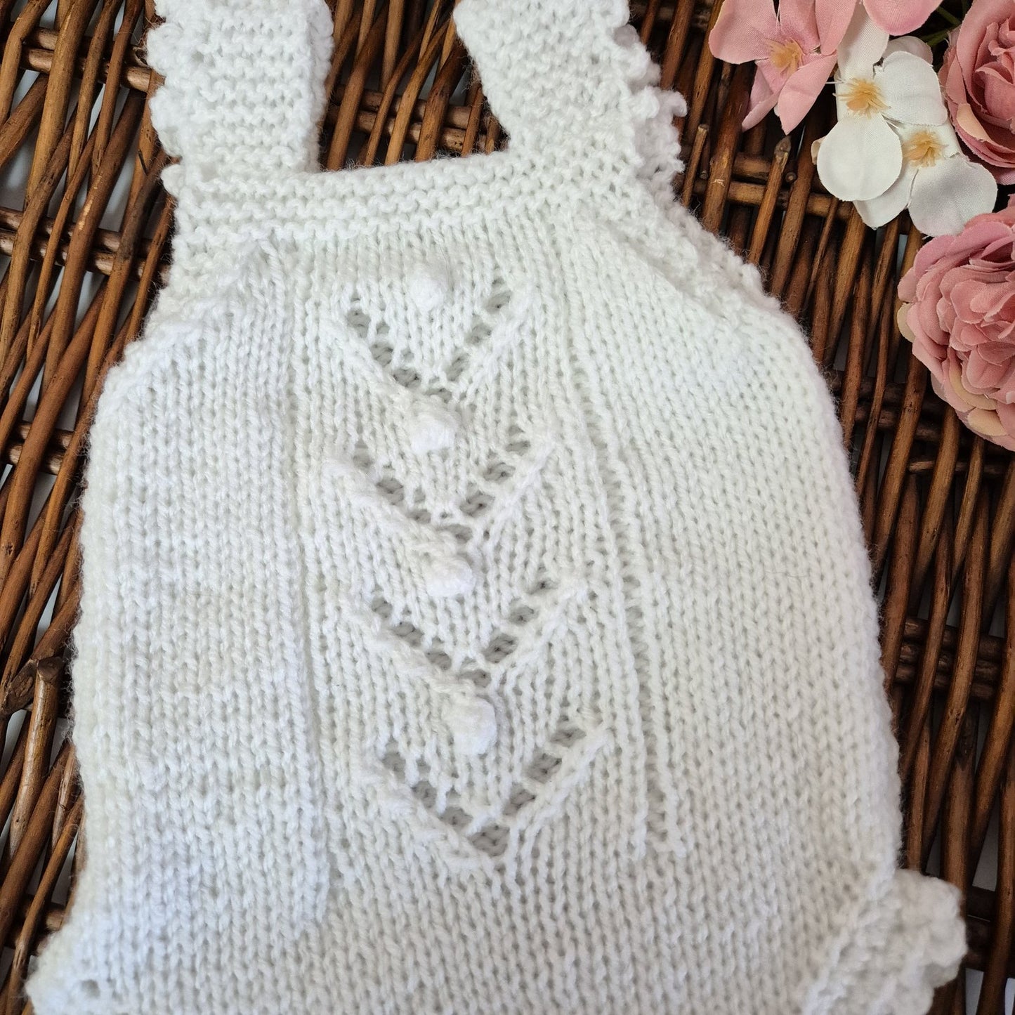 A sweet handknit lace and popcorn romper for a baby girl from newborn to 3 months old.

The darling little romper has a lace and popcorn pattern panel down the front, with scalloped frill on the legs and shoulder straps.