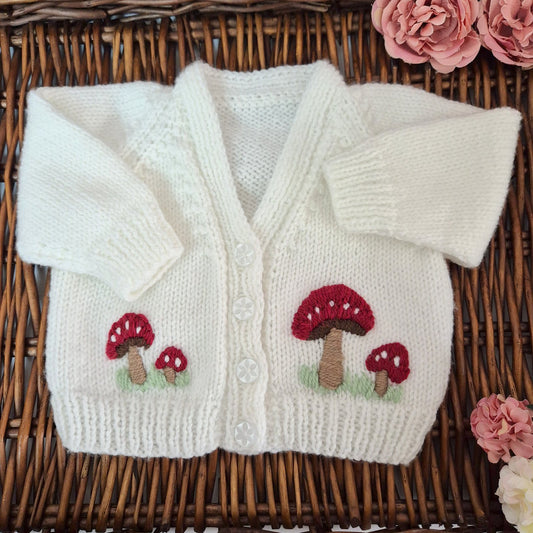 White hand knit baby cardigan with embroidered red toadstools. &nbsp;Jumper, 0-3 months Sweater
A gorgeous hand knit baby cardigan to fit a baby of 0-3 months&nbsp; This little jumper has white buttons on the top of the bodice, with&nbsp; little red toadstools embroidered on the front.&nbsp;